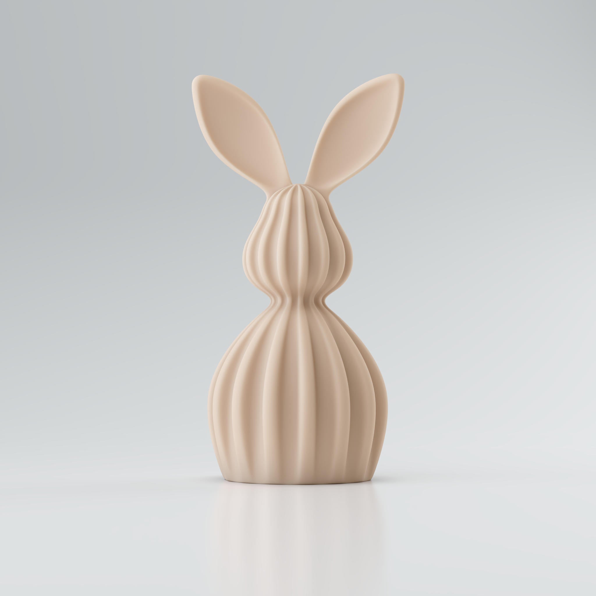 Kaninchenfigur aus beigem, glattem Material mit langen Ohren und geripptem Mittelteil vor hellem Hintergrund.