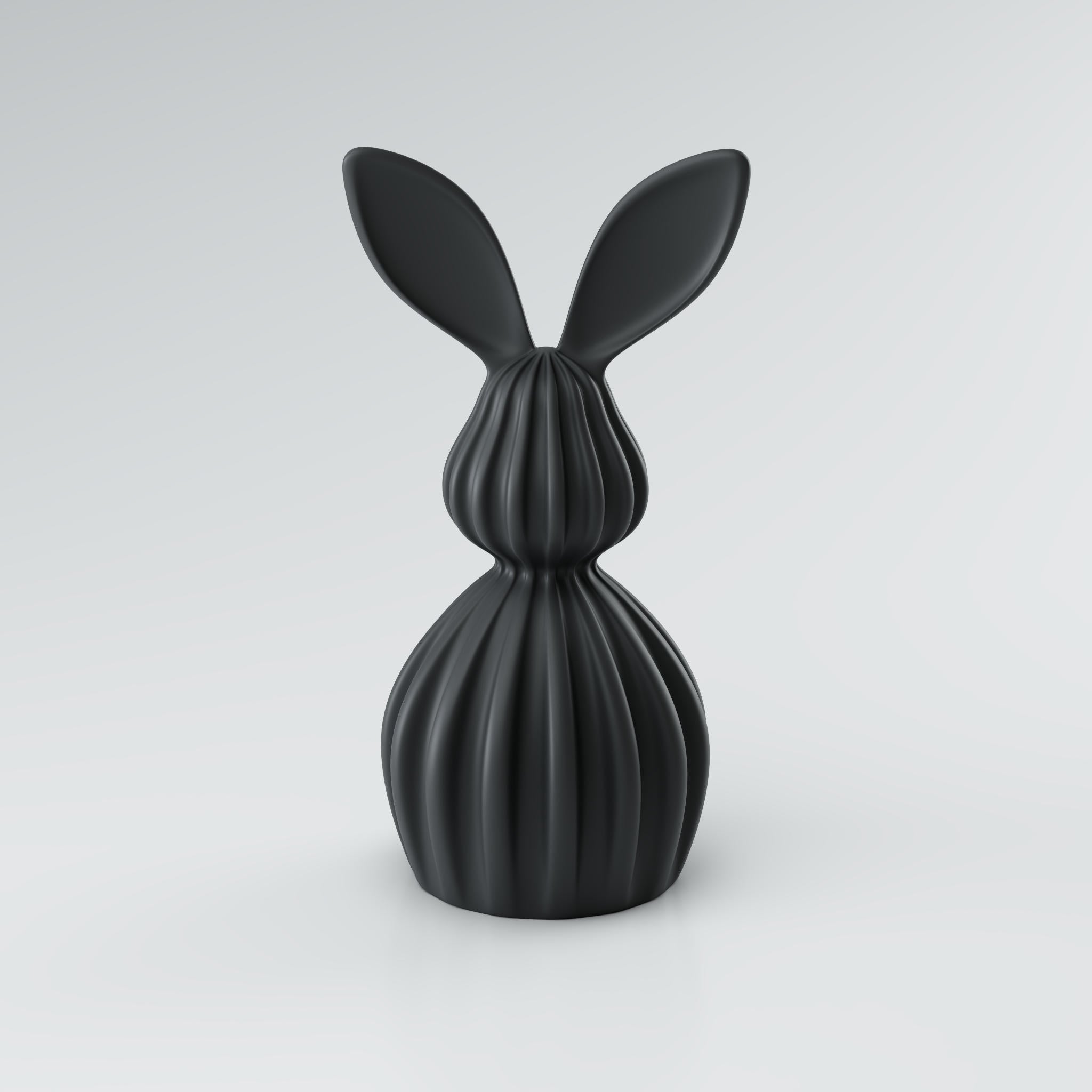 Schwarze abstrakte Hasenfigur aus 3D-Kunststoff mit langen Ohren und feinen Rillen vor hellem Hintergrund.