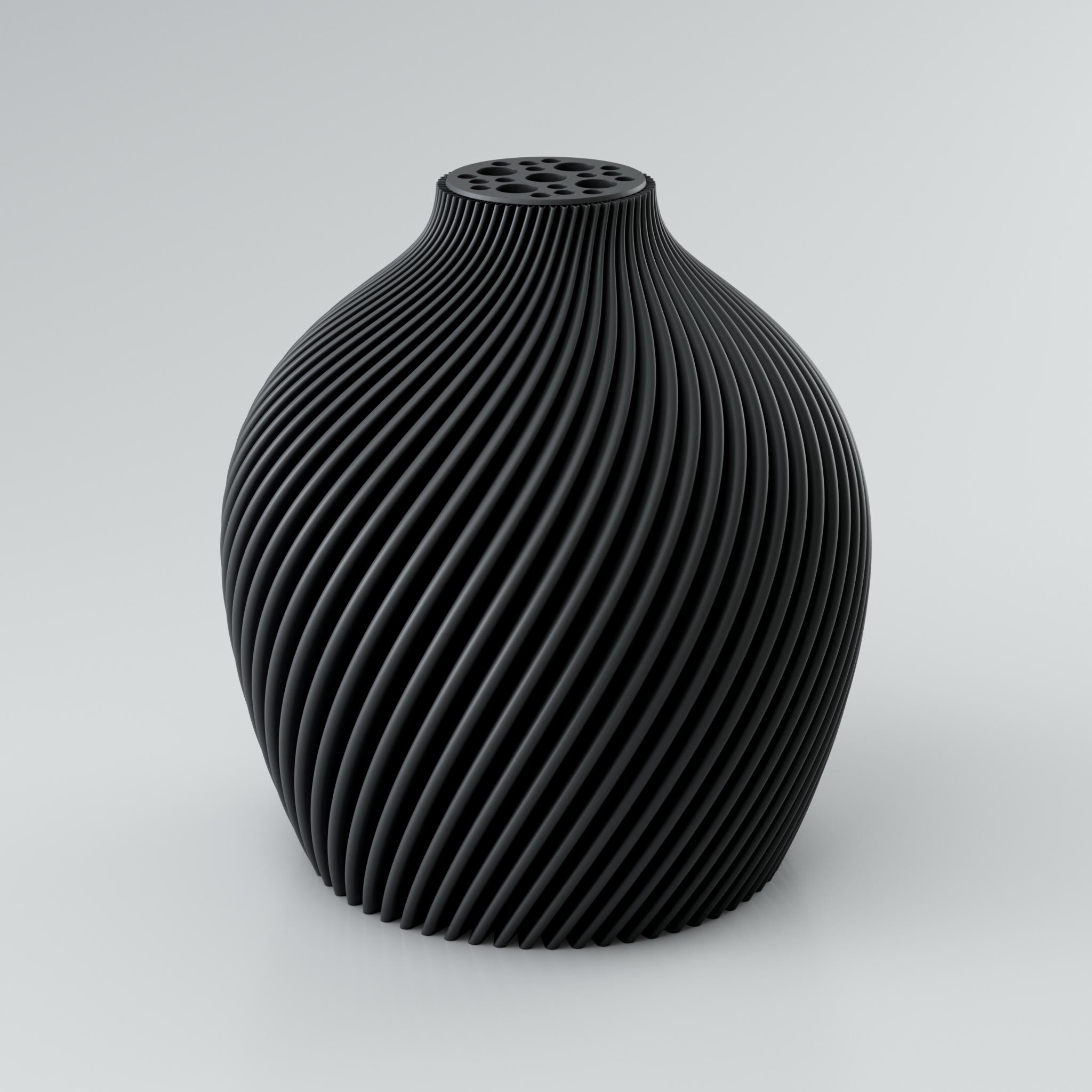 Eine spiralförmige, skulpturale Vase in Taupe mit einer markanten Rippstruktur. Die Oberfläche der Vase ist matt und weist klare Kanten auf, die ein intensives Licht- und Schattenspiel erzeugen. Am oberen Ende befindet sich ein integrierter Blumenretter mit mehreren unterschiedlich großen Löchern, ideal für Trockenblumen. Die Vase steht auf einer hellgrauen Oberfläche.