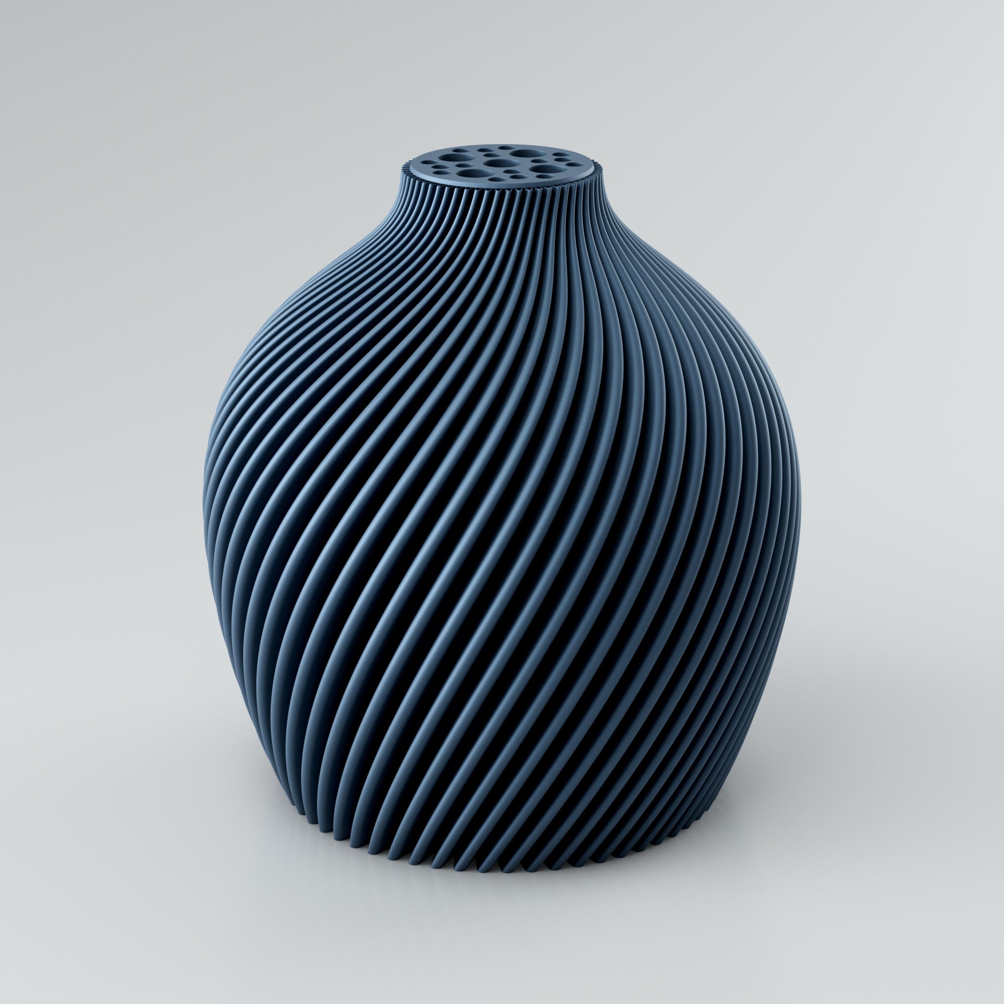 Eine spiralförmige, skulpturale Vase in Taupe mit einer markanten Rippstruktur. Die Oberfläche der Vase ist matt und weist klare Kanten auf, die ein intensives Licht- und Schattenspiel erzeugen. Am oberen Ende befindet sich ein integrierter Blumenretter mit mehreren unterschiedlich großen Löchern, ideal für Trockenblumen. Die Vase steht auf einer hellgrauen Oberfläche.