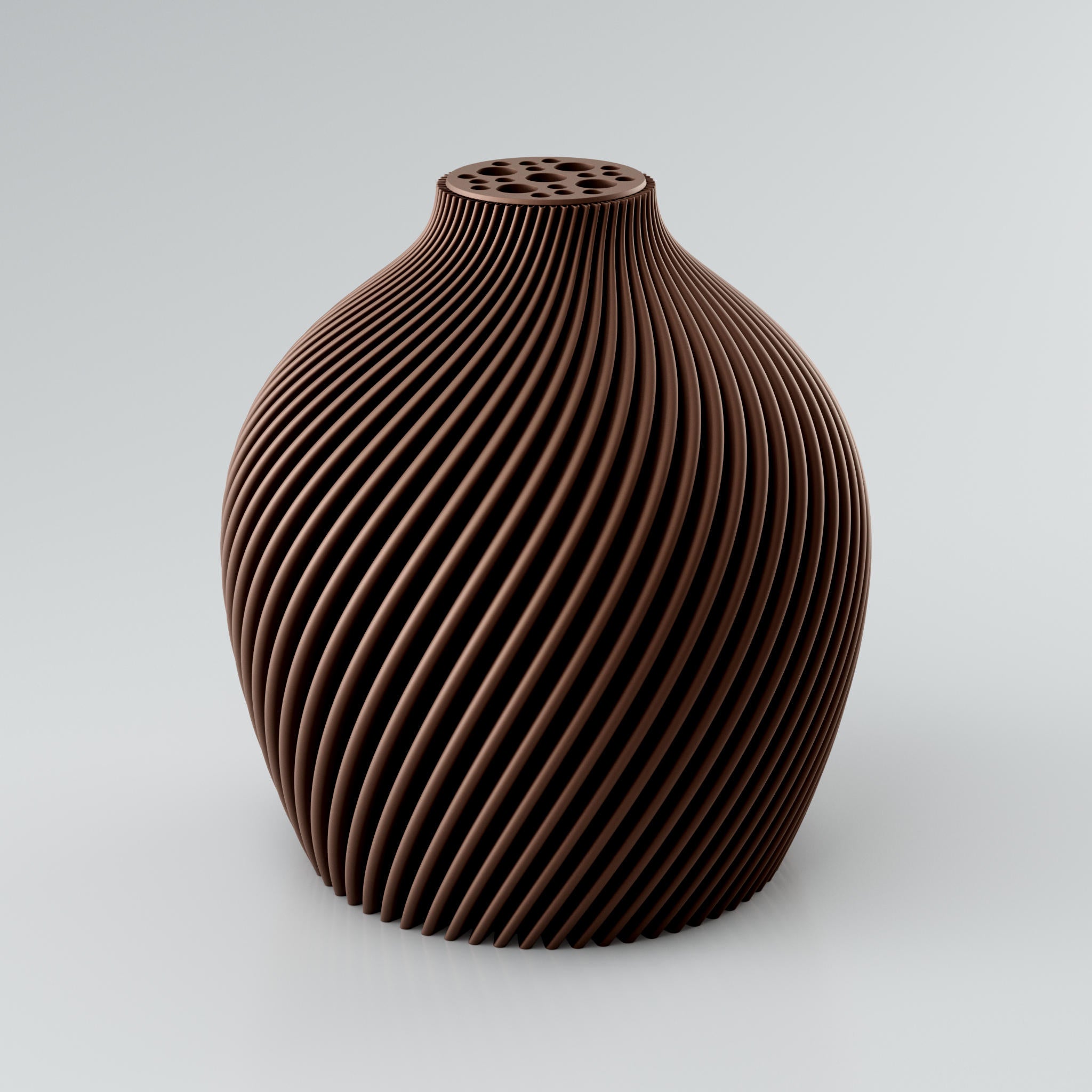 Eine spiralförmige, skulpturale Vase in Taupe mit einer markanten Rippstruktur. Die Oberfläche der Vase ist matt und weist klare Kanten auf, die ein intensives Licht- und Schattenspiel erzeugen. Am oberen Ende befindet sich ein integrierter Blumenretter mit mehreren unterschiedlich großen Löchern, ideal für Trockenblumen. Die Vase steht auf einer hellgrauen Oberfläche.