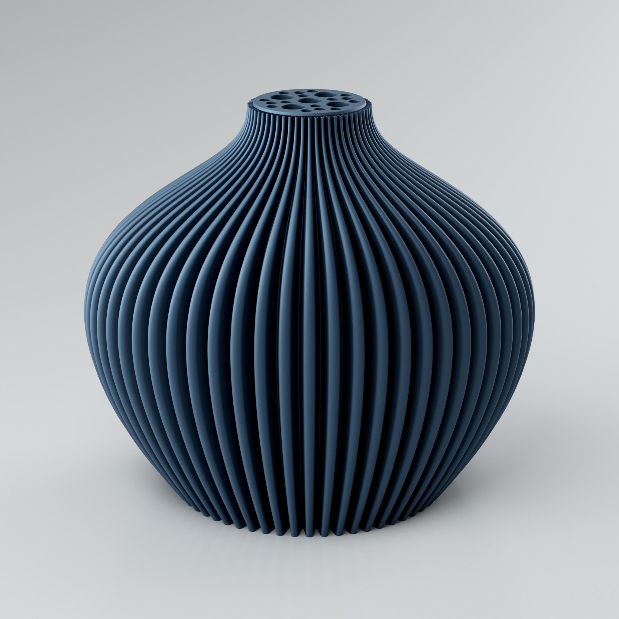 Eine moderne, beigefarbene Designvase "Voravellie 80" von Blooming3D. Die Vase hat eine ausgeprägte, präzise Rippstruktur, die ein faszinierendes Licht- und Schattenspiel erzeugt. Am oberen Ende befindet sich ein integrierter Blumenretter mit unterschiedlich großen runden Öffnungen für stilvolle Trockenblumenarrangements. Die modulare, skulpturale Form vereint Architektur und Design in einem Objekt. Die klaren Kanten der Rippenstruktur sind gut sichtbar. Die Vase steht auf einem hellgrauen Untergrund.
