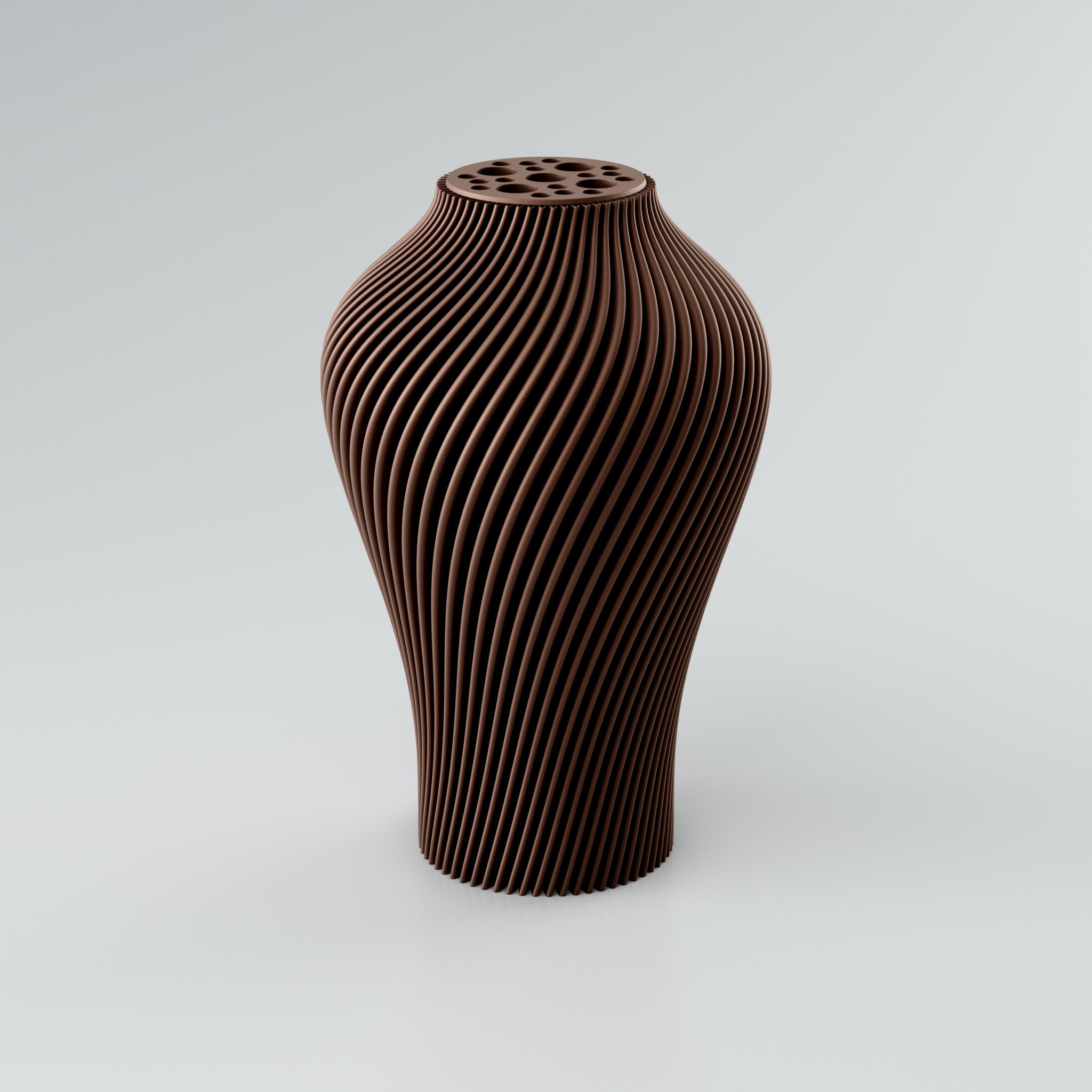 Eine hohe, skulpturale Vase in einem gedämpften Taupe-Ton steht auf einem hellgrauen Hintergrund. Die Vase hat eine ausgeprägte, spiralförmige Rippenstruktur, die sich von der Basis bis zum Hals windet und ein dynamisches Licht- und Schattenspiel erzeugt. Der Hals der Vase ist leicht verengt und mit einer runden Platte versehen, die mehrere unregelmäßig geformte Öffnungen aufweist, ideal für Trockenblumen. Die Oberfläche der Vase wirkt modern und konstruiert, mit klaren Kanten, die ihre architektonische...