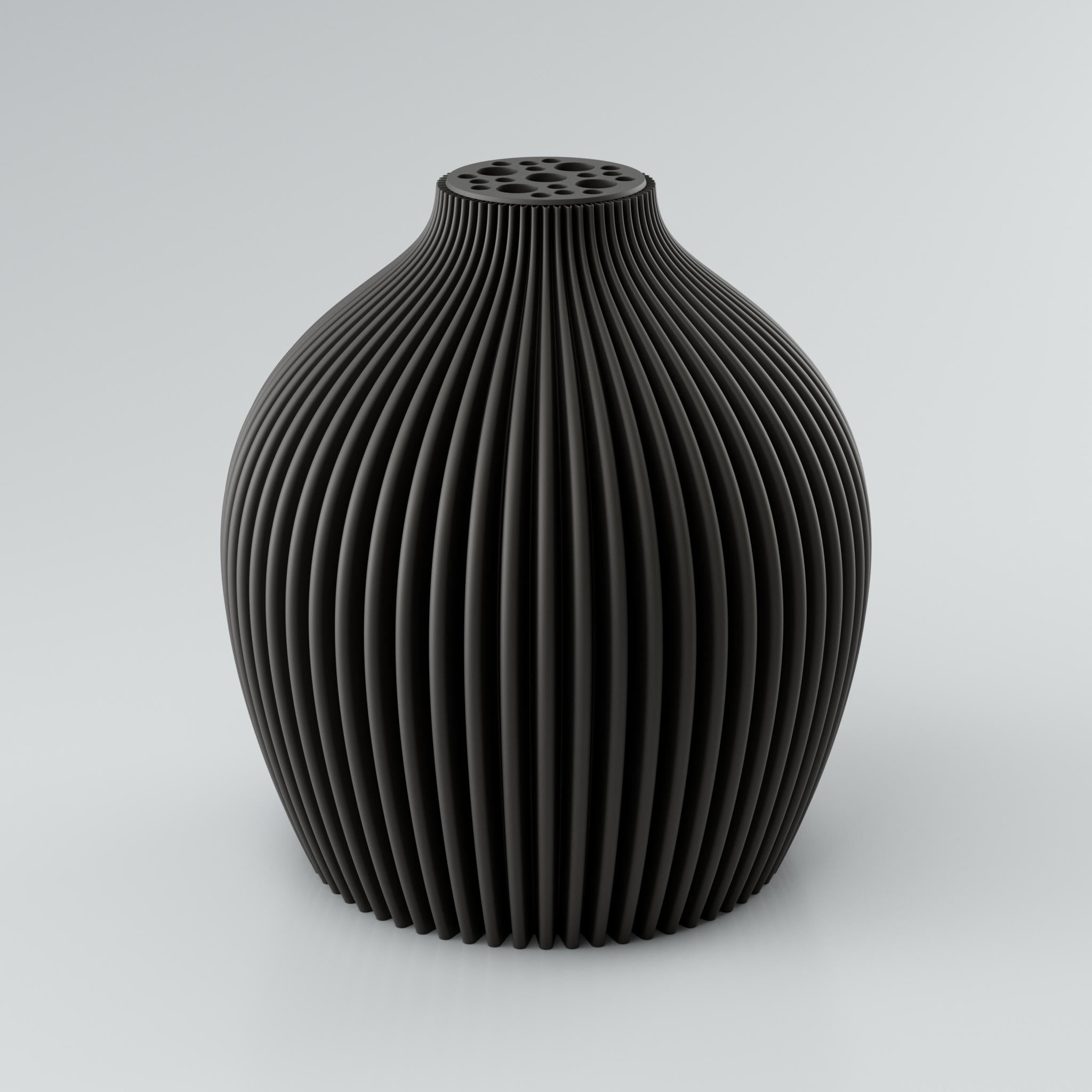 Eine moderne, modulare Designvase namens Voravellie 60 von Blooming3D in einem sanften Beigeton. Die Vase hat eine skulpturale Form mit einer ausgeprägten, präzise ausgearbeiteten Rippstruktur, die für ein faszinierendes Licht- und Schattenspiel sorgt. Am oberen Ende befindet sich ein integrierter Blumenretter mit unterschiedlich großen runden Öffnungen, ideal für stilvolle Trockenblumenarrangements. Die klaren Kanten und die dynamische Form vereinen Architektur und Design in einem Objekt. Die Vase...