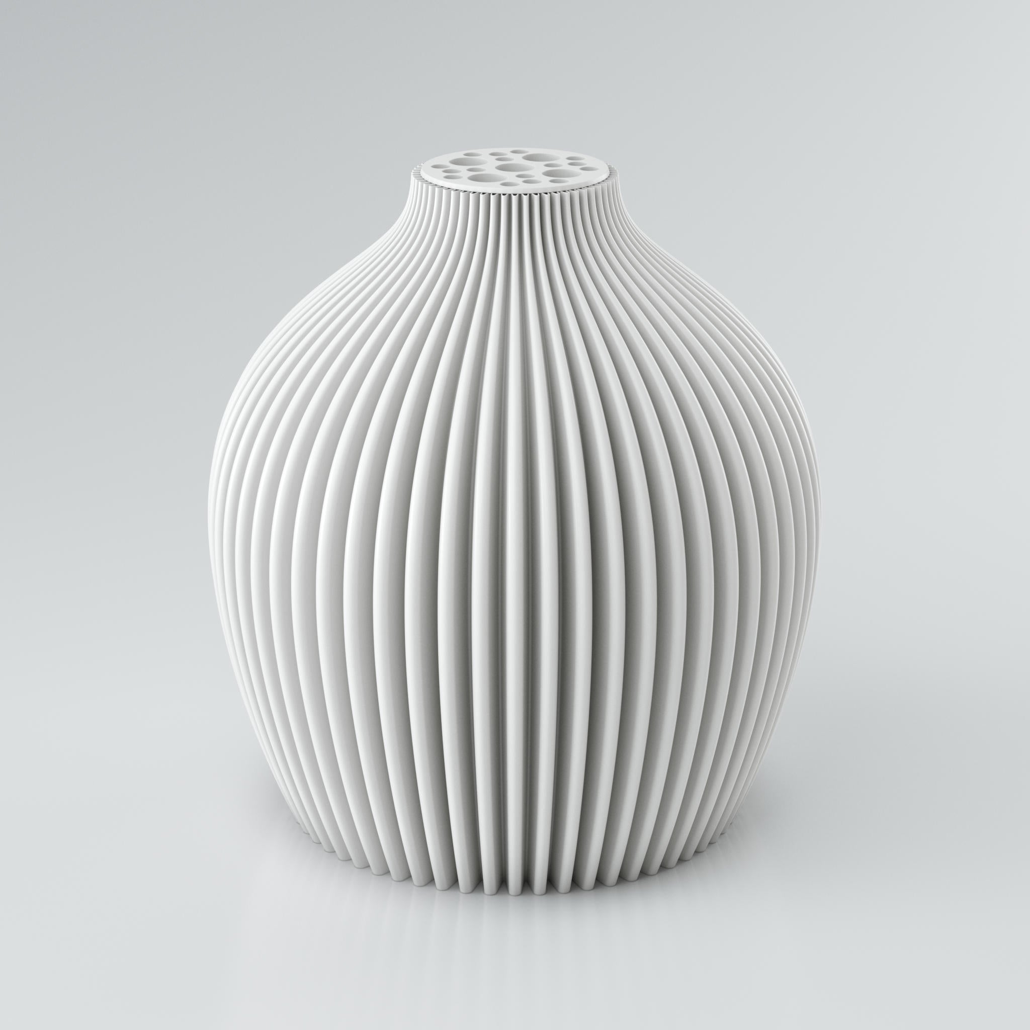 Eine moderne, modulare Designvase namens Voravellie 60 von Blooming3D in einem sanften Beigeton. Die Vase hat eine skulpturale Form mit einer ausgeprägten, präzise ausgearbeiteten Rippstruktur, die für ein faszinierendes Licht- und Schattenspiel sorgt. Am oberen Ende befindet sich ein integrierter Blumenretter mit unterschiedlich großen runden Öffnungen, ideal für stilvolle Trockenblumenarrangements. Die klaren Kanten und die dynamische Form vereinen Architektur und Design in einem Objekt. Die Vase...
