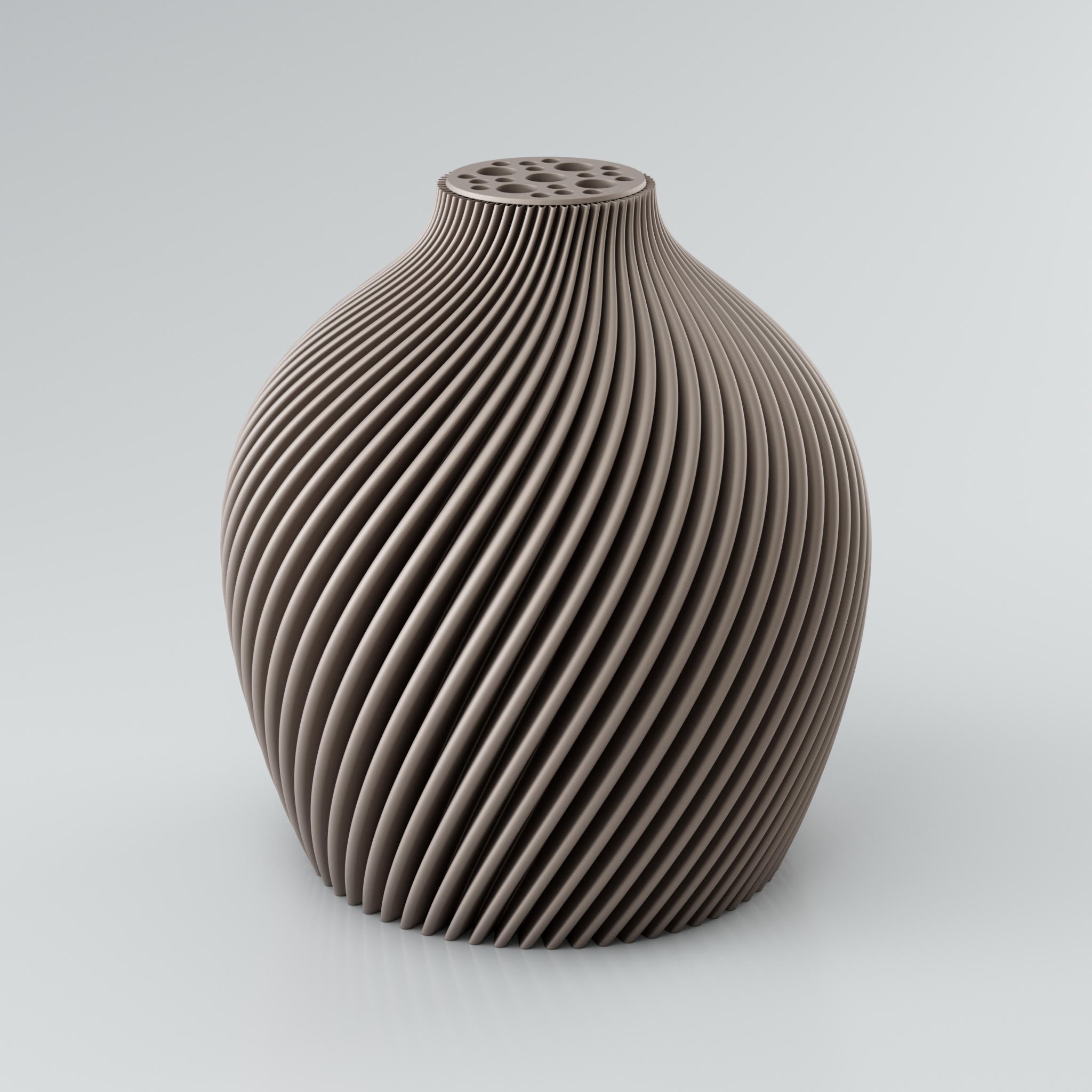 Eine spiralförmige, skulpturale Vase in Taupe mit einer markanten Rippstruktur. Die Oberfläche der Vase ist matt und weist klare Kanten auf, die ein intensives Licht- und Schattenspiel erzeugen. Am oberen Ende befindet sich ein integrierter Blumenretter mit mehreren unterschiedlich großen Löchern, ideal für Trockenblumen. Die Vase steht auf einer hellgrauen Oberfläche.